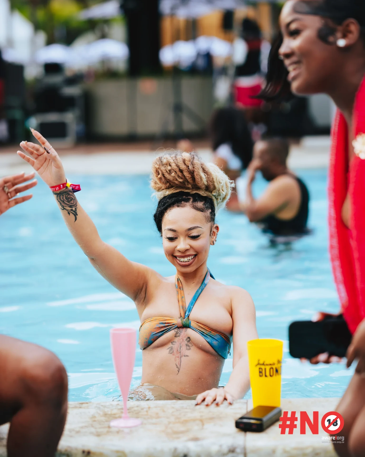 Guest dancing in the pool with drinks at the day party